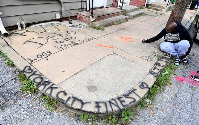 Najah Weedon of York City adds a memorial on the sidewalk near where a fatal shooting occurred on North Pine Street Friday, Sept. 6, 2019. She said she was a best friend of the victim. Bill Kalina photo