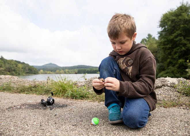Bentley McClarren, 6, attempts to bait his own hook on his own at a dock at the Ross Lake fishing at the Annual Family Fishing Day on September 7, 2019. 