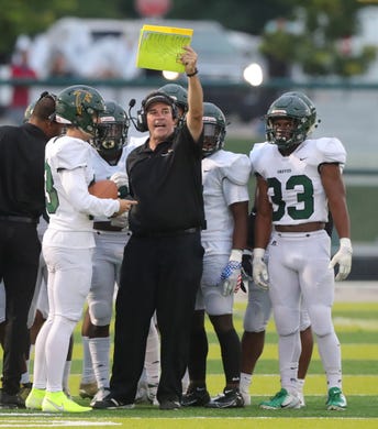 Birmingham Groves Falcons head coach Brendan Flaherty talks with his players during the game against the West Bloomfield Lakers on Friday, Sept. 6, 2019 at West Bloomfield high school.
