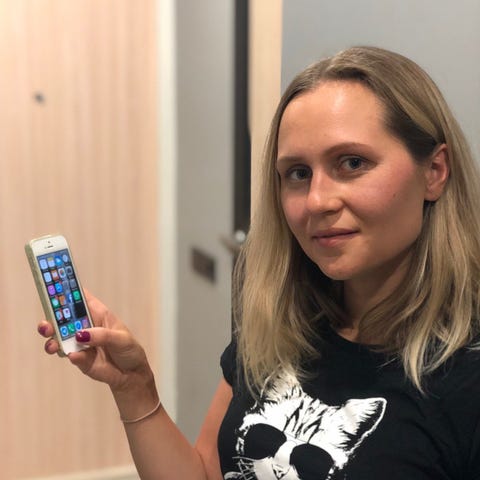 Anna Komok of Russia holds up her old iPhone 5S ph