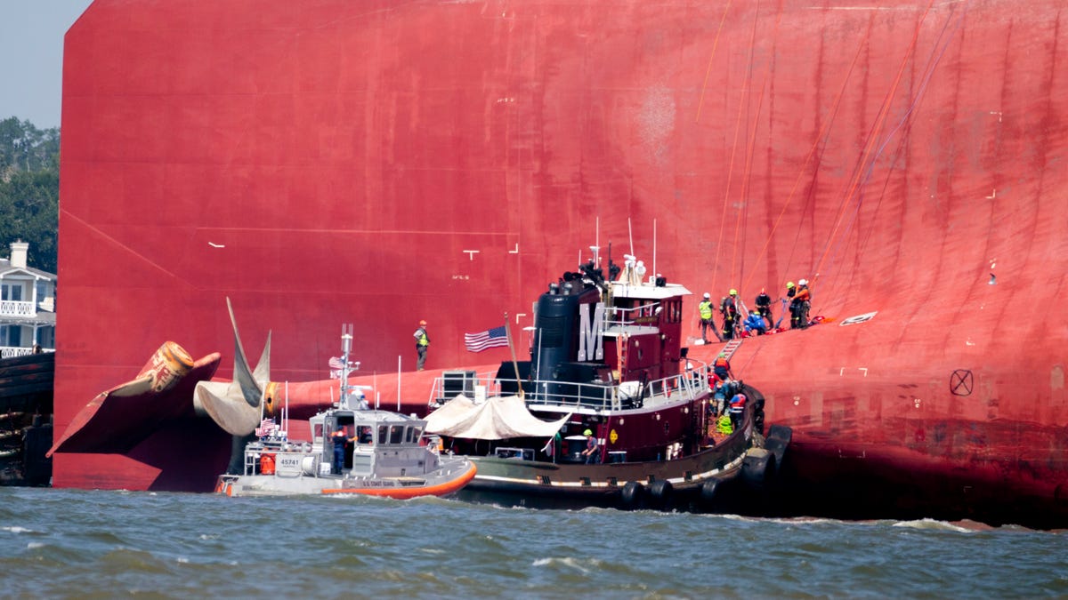 Rescuers work near the stern of the vessel Golden Ray as it lays on its side near the Moran tug boat Dorothy Moran on Sept. 9, 2019, near Jekyll Island, Ga. 