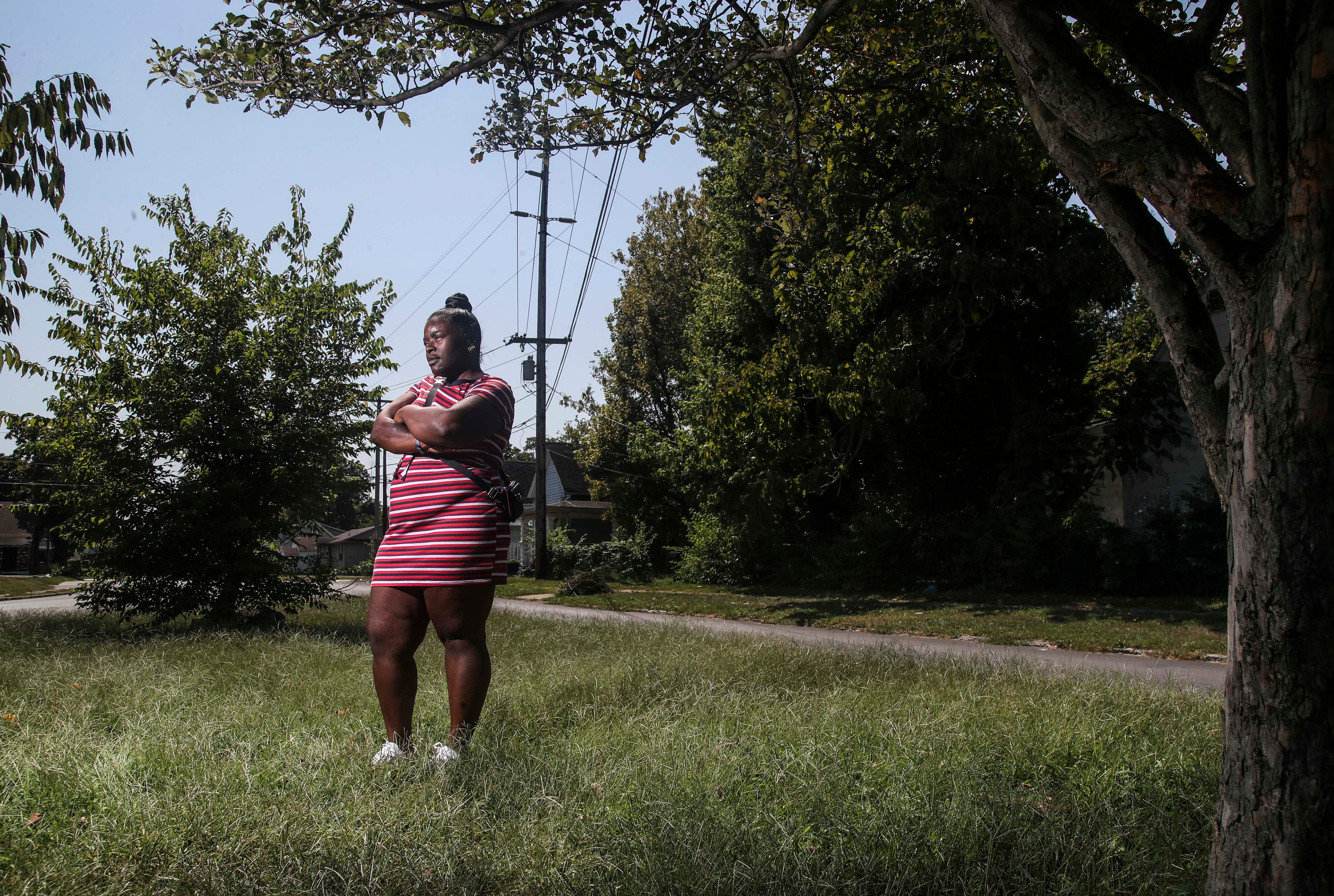 Ryan Sellers stands in the median at the corner of Garland Avenue and Louis Coleman Jr. Drive. In July, she was thrown from her car at the intersection after being hit by a suspect who stole a car and ran a red light while being pursued by police.