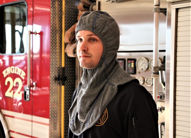 Firefighter Andrew Niles from the Marion Fire Department displays one of the new particulate-blocking hoods the department has purchased. A community fundraising campaign generated about $15,000 for the department to pay for the hoods, which officials say block 99 percent of contaminants from reaching firefighters' skin.
