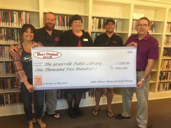 From left: Moe BBQ’s Kara Gallagher and Greg Tracey, Granville Public Library Director Anita Carroll, Justin Palm of Moe’s, and Daniel Lavely during a recent check presentation at the library.