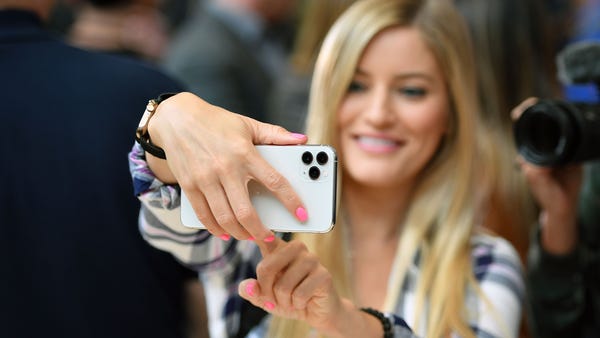 A woman tries out a new Apple 11 Pro during an App