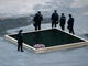 A group of police officers look at the North Tower reflecting pool on September 11, 2006 before a ceremony at the site of the former World Trade Center marking the fifth anniversary of the September 11th attacks, in New York. 
