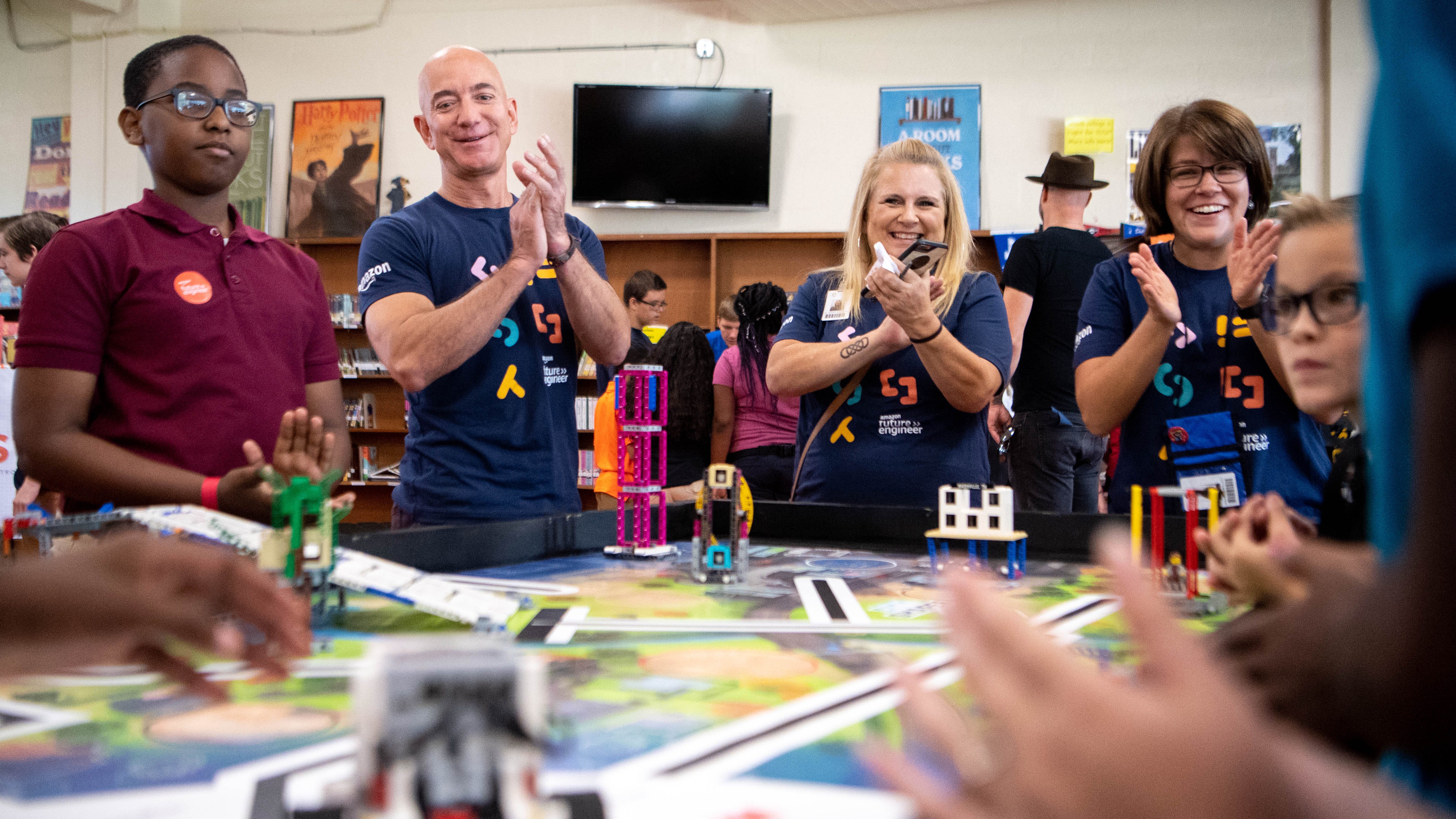 Amazon CEO Jeff Bezos applauds as students work with a robot at Madison Middle School Wednesday, September 11, 2019 in Nashville, Tenn.