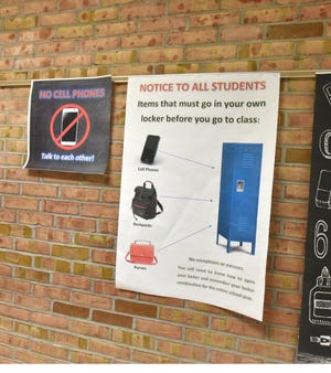 Posters announcing the new procedure for no backpacks or cell phones in classrooms at Westland's Stevenson Middle School line its hallways.