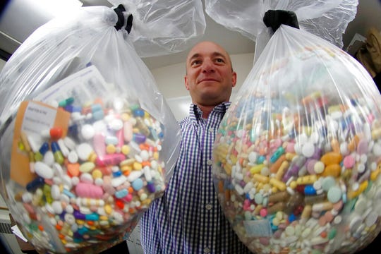 Narcotics detective Ben Hill shows two bags of medication that are slated for destruction on Sept. 11, 2019, in Barberton, Ohio.