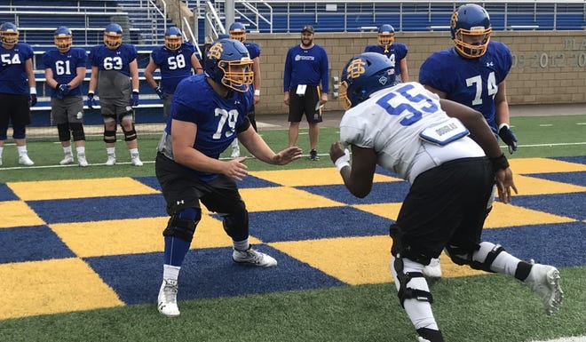 Grant Schmidt (79) takes on teammate Thomas Stacker (55) in a pass blocking drill Wednesday at Dana J. Dykhouse Stadium