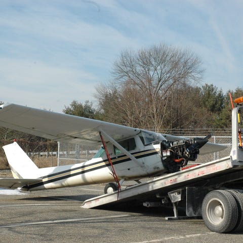 A Cessna is loaded onto a flatbed truck after maki