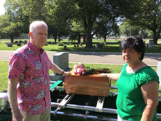 JIm and Gloria Matthews touch the small casket containing their youngest daughter's remains in mid-August. Jonelle was reburied during a service at Linn Grove Cemetery in Greeley.