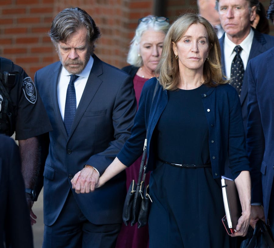 Felicity Huffman and her husband, actor William H Macy, leave the federal courthouse in Boston following her sentencing in the college admission scandal, Sept. 13, 2019. She was sentenced to 14 days in prison, $30,000 fine and 250 hours of community service.