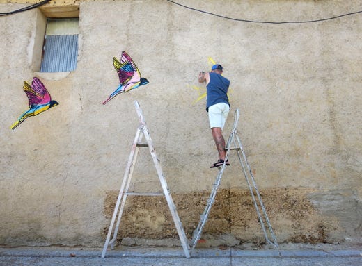 Urban artist Piahomes works on his mural in the remote village of Castrogonzalo, Spain on Aug. 30, 2019. Every year Madrid Street Art Project, an organization that champions urban art, and Feliz invite a group of artists to visit the Spanish village for a community event to celebrate and contribute to the growing collection of street art.