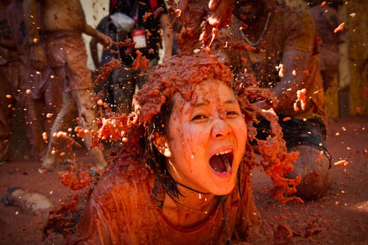 A reveller covered in tomato pulp participates in the annual "Tomatina" festival in Bunol, Spain on Aug. 28, 2019. The iconic fiesta, which is billed at "the world's biggest food fight" has become a major draw for foreigners, in particular from Britain, Japan and the United States.