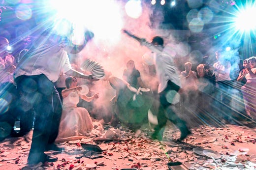 People dance to a traditional greek music amid broken plates, during wedding celebrations in Athens early on Sept. 8, 2019.