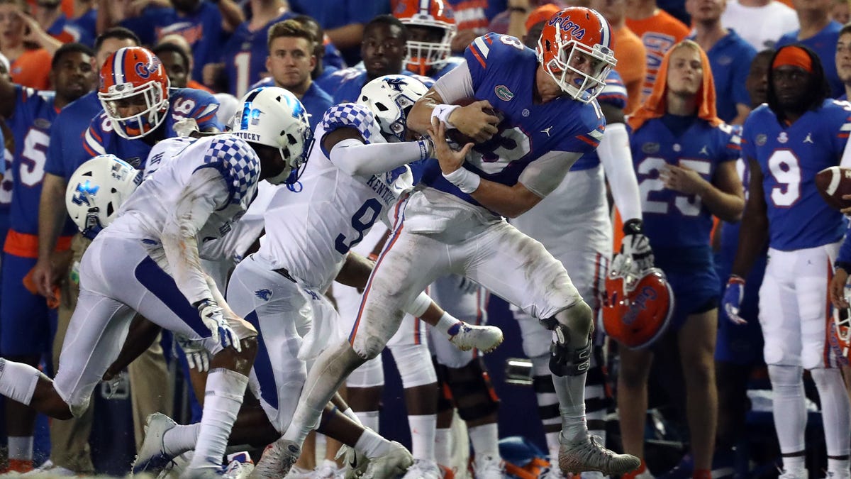 Florida quarterback Feleipe Franks  runs with the ball as Kentucky safety Davonte Robinson (9) defends during their game in 2018.