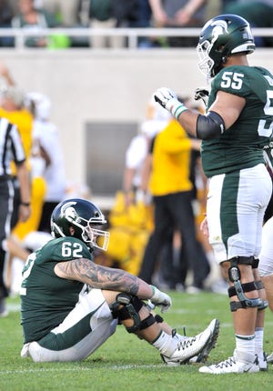 Luke Campbell (62) and Jordan Reid (55) are dejected after MSU's loss to Arizona State.