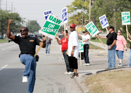 Randolph Walker cheers on motorist as they blow their horns in support of the strike at GM's Powertrain Plant in Warren in 2007.