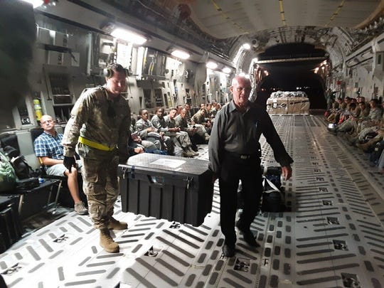 A U.S. Air Force flight carrying the remains of the 81 South Vietnamese soldiers arrives in Southern California on Sept. 13, 2019. They were escorted by retired Col. Gene (Gino) Castagnetti, right, former director of the National Memorial Cemetery of the Pacific, to a mortuary in Westminster, California.
