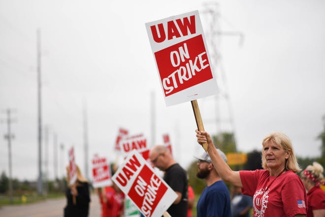 UAW members, including LeAnn Cramer, right, picket outside of the General Motors Lansing Delta Township plant early Monday morning, Sept. 16, 2019, the first day of a nationwide strike against GM.   Cramer has worked at GM for 24 years.