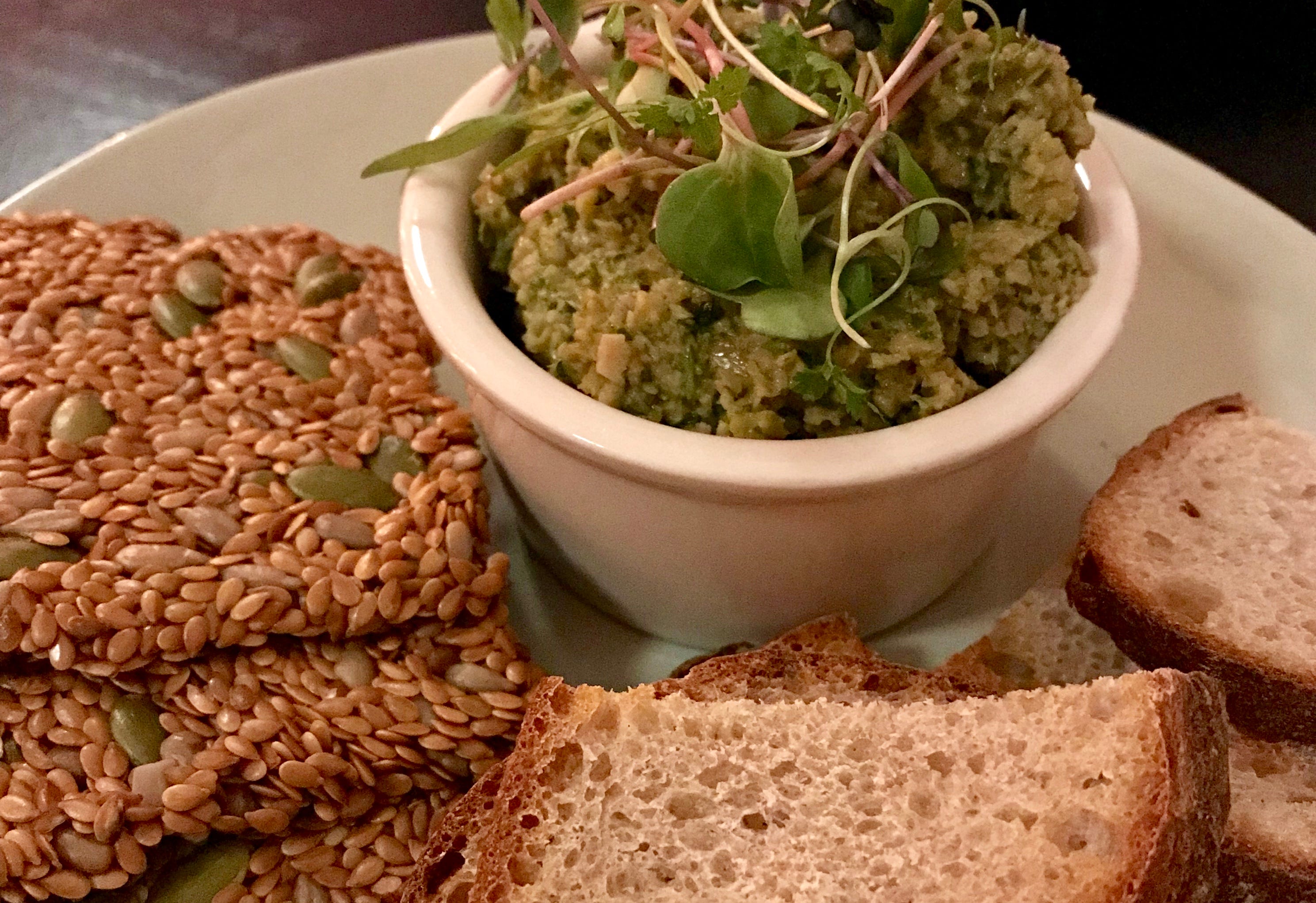 Olive tapenade with seed crackers and crusty bread is an example of the shareable plates on the changing, vegan menu at Strange Town, 2101 N. Prospect Ave.