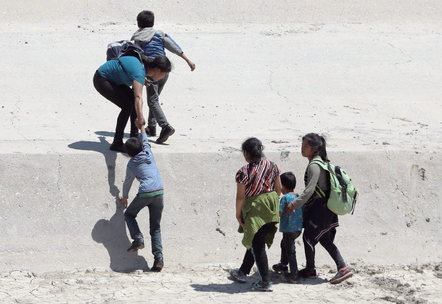 Two Cuban mothers and their children cross the American Canal between Juarez, Chihuahua, Mexico and El Paso, Texas on June, 25, 2019. The group slipped through a small gate in the border barrier that was open and entered the United States. Many asylum seekers subject to Migrant Protection Protocols are becoming impatient with the long waits in Mexico and are crossing illegally and risking detention.