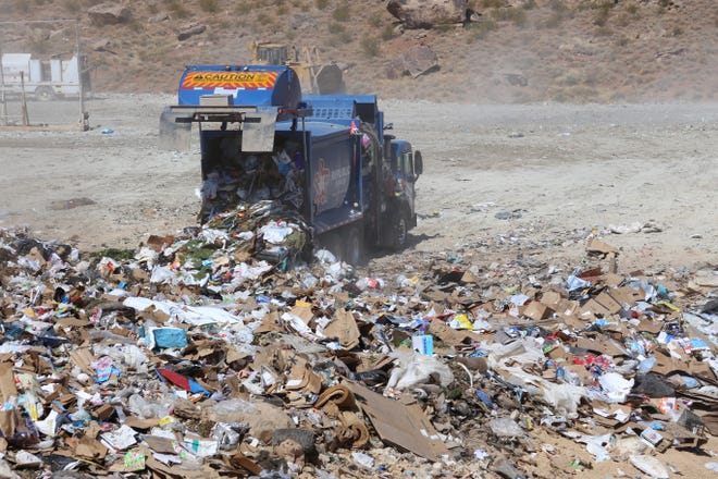 A Republic Services collection truck dumps a load at the county landfill.