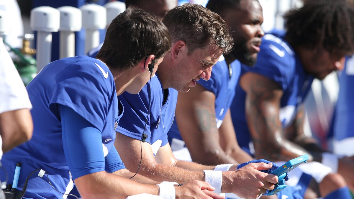 New York Giants quarterbacks Eli Manning (10) and Daniel Jones (8) look at film on the sideline during the fourth quarter against the Buffalo Bills at MetLife Stadium.