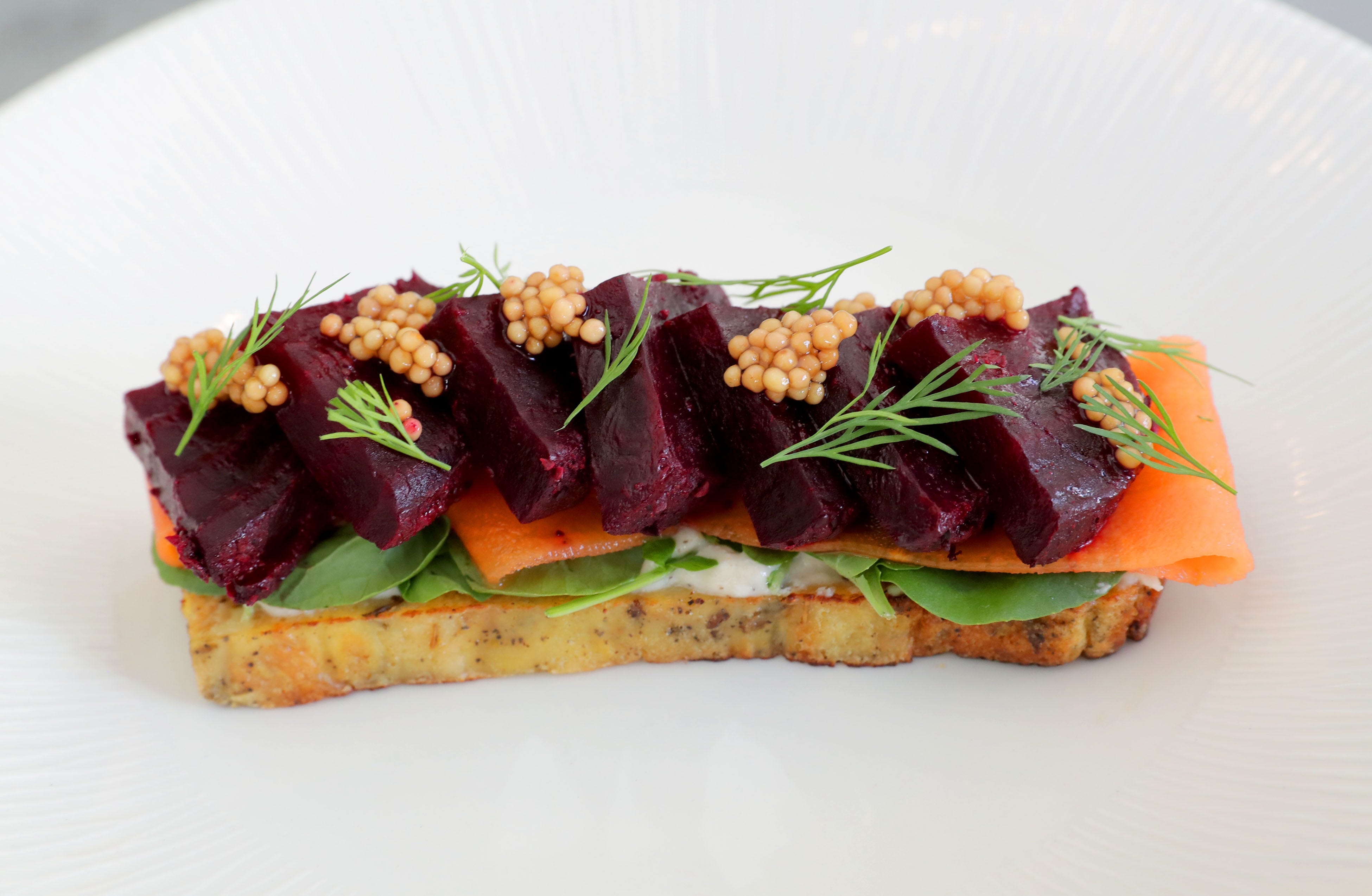 Beets seasoned to taste like pastrami are placed over pain perdu — French toast — with spiced pickled mustard seeds, watercress, horseradish creme fraiche, and pickled carrots for an appetizer at Buckley's Restaurant.