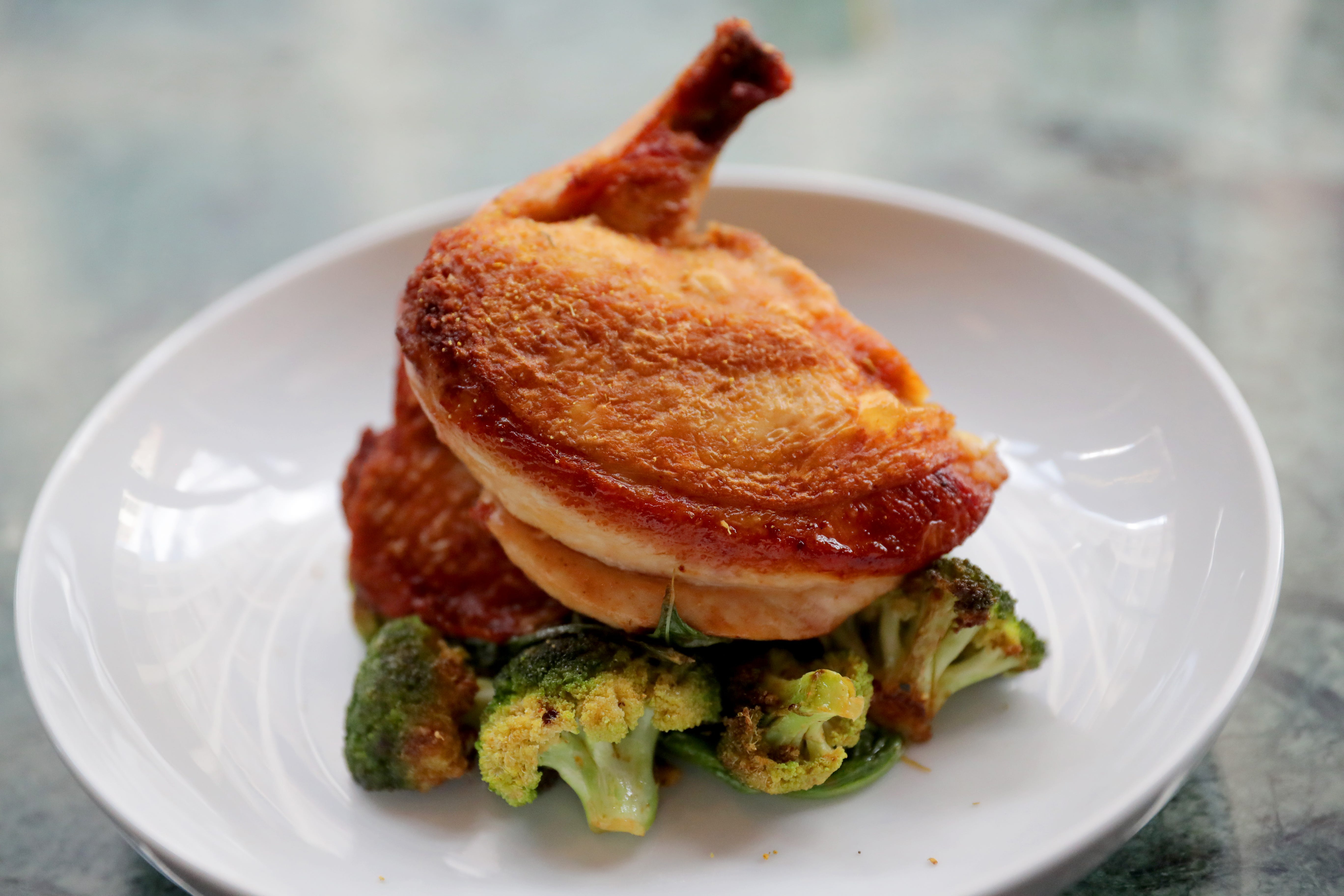 Roasted half-chicken at Fauntleroy is served over collard and mustard greens and broccoli with lemon vinaigrette.