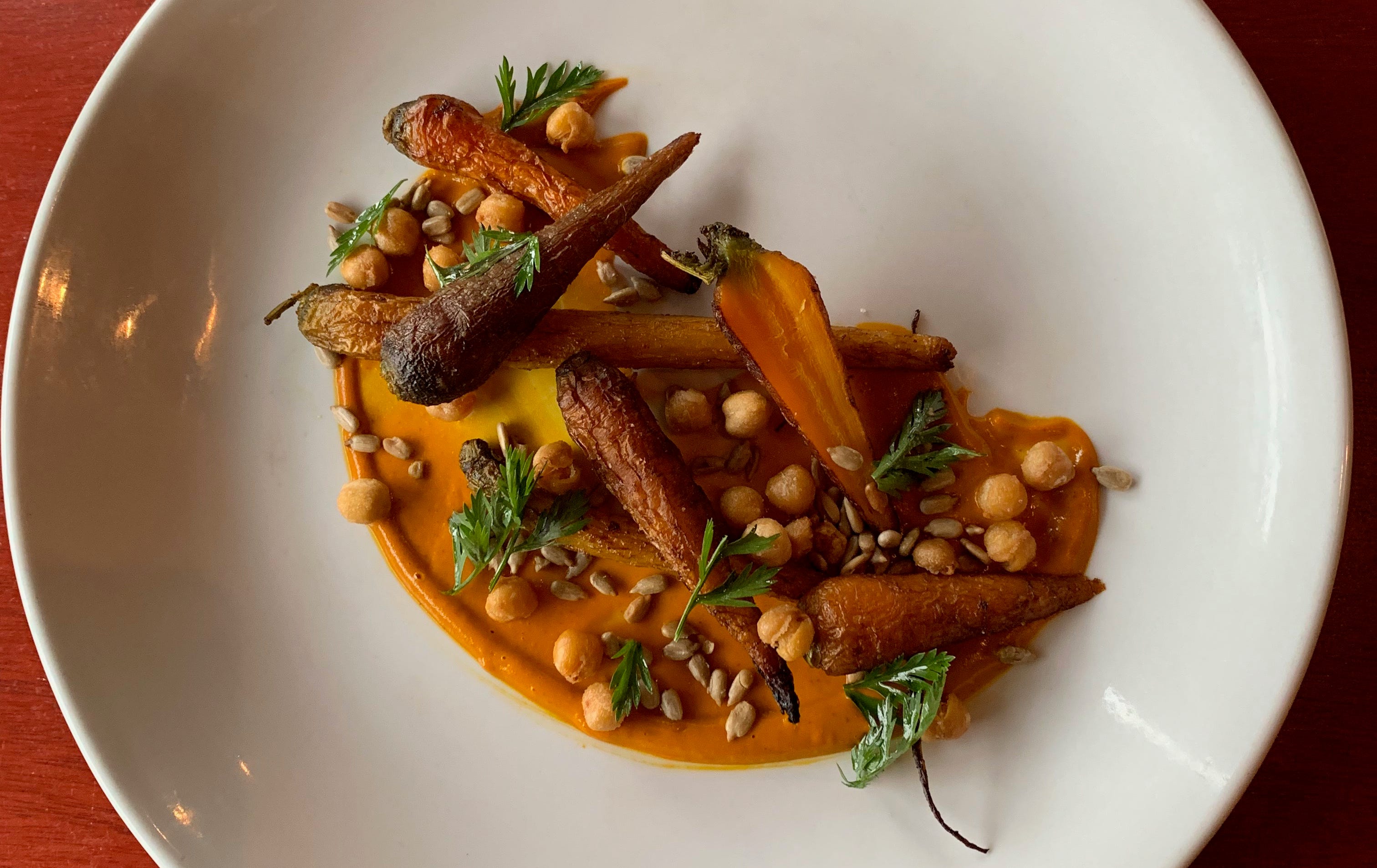 Carrot barbecue sauce is the bed for roast carrots, fried chickpeas and sunflower seeds, a dish at the Diplomat, 815 E. Brady St.