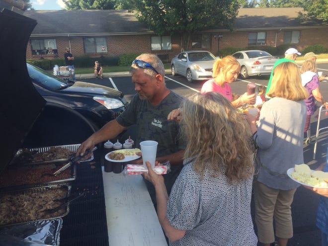 Joel Lively (left) of Papa Joe’s Hometown BBQ serves up meals in the parking lot of Pataskala Oaks Sept. 17.