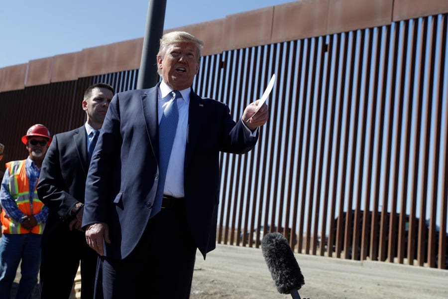 President Donald Trump talks with reporters as he tours a section of the southern border wall, Wednesday, Sept. 18, 2019, in Otay Mesa, Calif.
