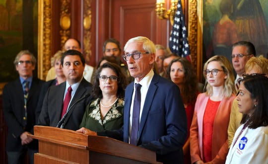 Wisconsin Gov. Tony Evers, center, speaks during a press conference announcing new gun safety reform legislation, Thursday, Sept. 19, 2019, in the Governors conference room in Madison, Wis.