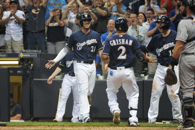 Brewers centerfielder Trent Grisham  is greeted by Travis Shaw (21) and Keston Hiura after both Grisham and Shaw scored as a result of bad throws in the sixth inning.