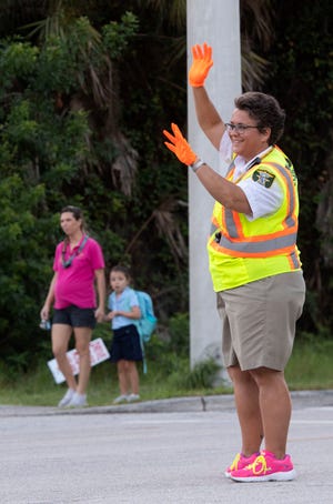 Michelle Strunk, a Martin County Sheriff's Office traffic control officer, directs vehicles, students and their families, including Paula Hartwick (left) and her daughter, Hobe Sound Elementary School kindergartner Kyleigh Hartwick, on Thursday, Sept 19, 2019, outside of the school in Hobe Sound. Strunk is in her 28th year as a crossing guard for the school and the job is part of her family's legacy. "My mom was the first ever crossing guard (at Hobe Sound Elementary School)," Strunk said. "That was a few bosses ago."