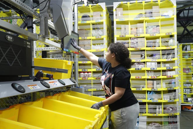 In this June 26, 2019, file photo a worker sorts through items and places orders at the Amazon Fulfillment Center in Staten Island in New York. Amazon hopes to open a similar fulfillment center on the site of the old Pontiac Silverdome in Oakland County.
(AP Photo/Kathy Willens)