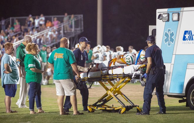Hooper Academy's Grant Tyson is attended to after being injured during a play early in the second quarter against Lowndes Academy. 