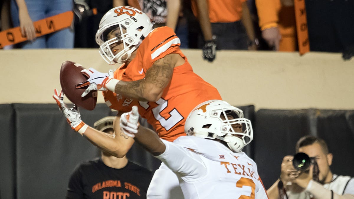 Oklahoma State receiver Tylan Wallace (2) makes a leaping grab over Texas defender Brandon Jones last October.