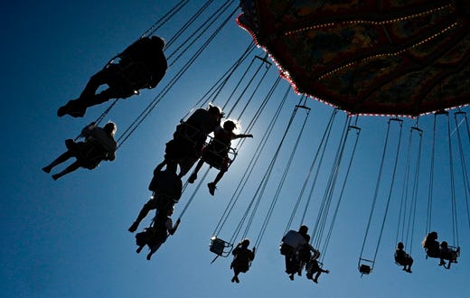 People ride a fun ride during the Oktoberfest beer festival at the Theresienwiese fair grounds in Munich, southern Germany, on Sept. 21, 2019. The world's biggest beer festival Oktoberfest opens today and runs until October 6, 2019. 