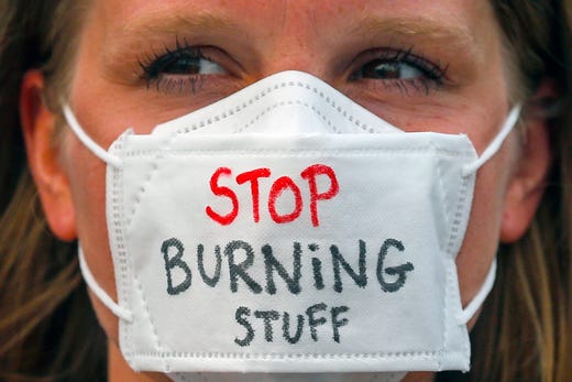 An environmental activist wears a mask with the words 'STOP BURNING STUFF' during a rally part of the international Global Climate Strike in Kuala Lumpur, Malaysia on Sept. 21, 2019. 