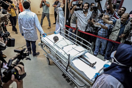 Journalists gather around the ancient Egyptian mummy of Sennedjem, an artisan who lived during the reigns of Pharaohs Seti I and Ramesses II in the 19th dynasty (13th-12th century BC), after being removed from its coffin for fumigation at the National Museum of Egyptian Civilization in the capital Cairo's Old Cairo district on Sept. 21 , 2019. 