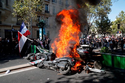 Motorcycles burn next to a barricade erected across a street during a Climate Change protest in Paris on Sept. 21, 2019. 