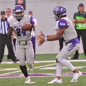 ACU quarterback Sema'J Davis, right, tosses a shovel pass to Tyrese White. White gained nine yards to the ACU 31 on the play in the Wildcats' Southland Conference game against McNeese on Sept. 21 at Wildcat Stadium.