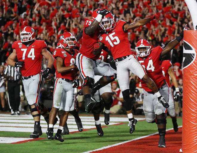 Georgia wide receiver Lawrence Cager (15) celebrates his 15-yard touchdown catch with Makiya Tongue and teammates during the fourth quarter.