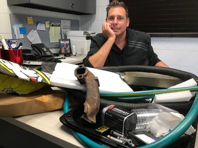 Lucas Dean, supervisor of the big SOCRRA recycling center in Troy, sits with his desk full of trash --  all items that shouldn't go into recycling carts or bins
