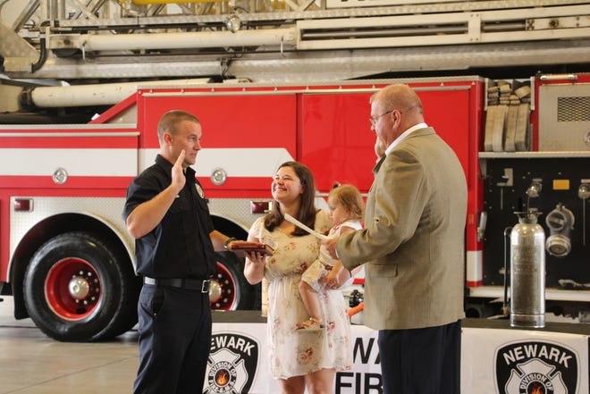 Jesse Myers (left) raises his hand on Monday, Sept. 23, 2019, to be sworn in as Newark Fire Department's newest firefighter/paramedic as Newark Safety Director Steve Baum reads the oath, and Myers' wife, Ashley, and daughter, Leah, look on. Myers started in fire service through Mary Ann Township as a volunteer, wanting to help the community in which he lived. A 2005 Licking Valley graduate, Myers attended CTEC and COTC and has served on departments in Mary Ann Township and Hebron.