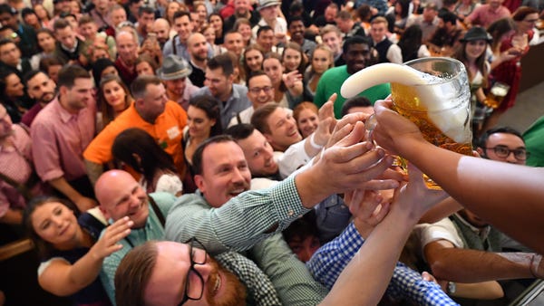 Visitors reach for the first mugs of beer in the P