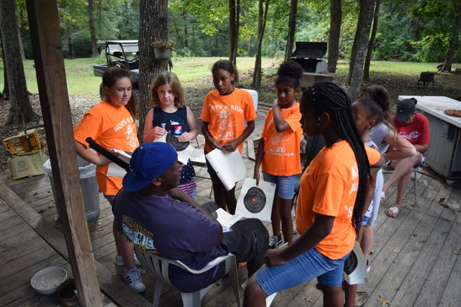 Campers at the Kops and Kids Adventure Program, a free camp put on by the St. Landry Sheriff's Office, listen intently to camp counselor Ron Rideau as he explains how to properly hold a gun.